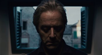 Movie still from “Certified Copy” (2010), directed by Abbas Kiarostami – A person wearing a black shirt; Close Up shot, Low angle