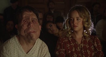 A man and a woman in front of a group of people