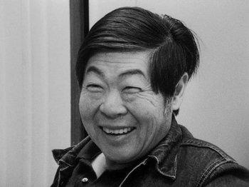 An older asian man smiling for the camera