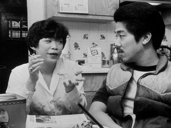 Movie still from “Chan Is Missing” (1982), directed by Wayne Wang – A man and a woman sitting at a table; Close Up shot, High angle