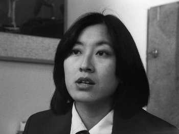 Movie still from “Chan Is Missing” (1982), directed by Wayne Wang – A black and white photo of a person in a suit; Close Up shot, Low angle
