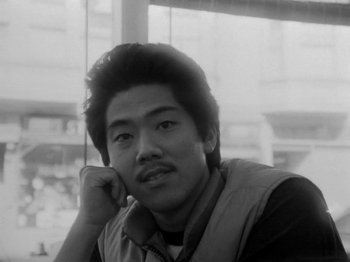 Movie still from “Chan Is Missing” (1982), directed by Wayne Wang – Black and white photograph of a young man in a vest; Close Up shot, Low angle