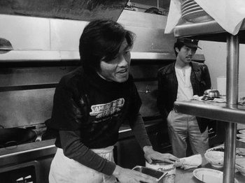 Movie still from “Chan Is Missing” (1982), directed by Wayne Wang – A man and a woman preparing food in a kitchen; Medium shot, Low angle