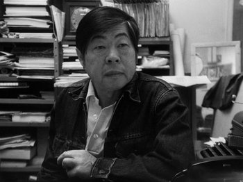 Movie still from “Chan Is Missing” (1982), directed by Wayne Wang – An older man sitting at a desk in front of papers; Close Up shot, High angle