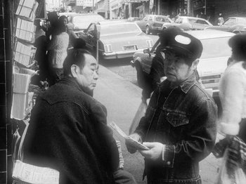 Movie still from “Chan Is Missing” (1982), directed by Wayne Wang – Two men standing next to each other on the street; Medium shot, High angle