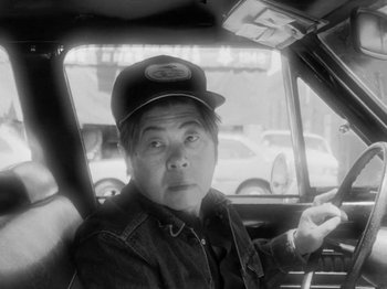Movie still from “Chan Is Missing” (1982), directed by Wayne Wang – An older man sitting in the driver's seat of a car; Close Up shot, Low angle