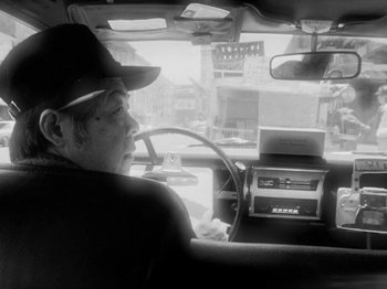 Movie still from “Chan Is Missing” (1982), directed by Wayne Wang – A black and white photo of a man driving a car; Close Up shot, Low angle