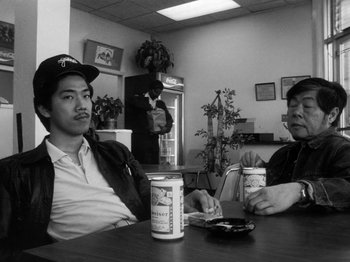 Movie still from “Chan Is Missing” (1982), directed by Wayne Wang – Two men sitting at a table drinking coffee; Medium shot, Low angle