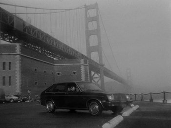 Movie still from “Chan Is Missing” (1982), directed by Wayne Wang – A car driving on a road near a bridge; Extreme Wide shot, Low angle