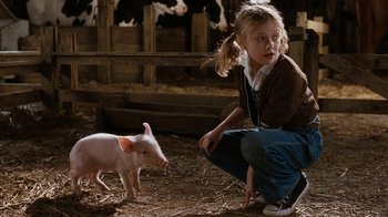 Movie still from “Charlotte's Web” (2006), directed by Gary Winick – A little girl and a piglet in a barn; Medium shot, High angle