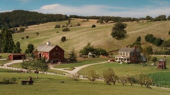 Movie still from “Charlotte's Web” (2006), directed by Gary Winick – A farm with a red barn and a house on the side of a hill; Extreme Wide shot, High angle