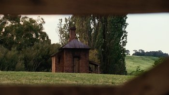Movie still from “Charlotte's Web” (2006), directed by Gary Winick – An old red brick house in the middle of a green field; Extreme Wide shot, High angle