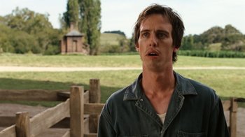Movie still from “Charlotte's Web” (2006), directed by Gary Winick – A man standing in front of a wooden fence; Close Up shot, Over the shoulder angle