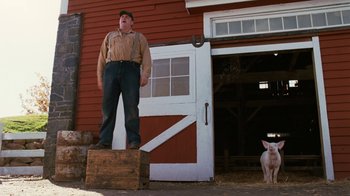 Movie still from “Charlotte's Web” (2006), directed by Gary Winick – A man standing on top of a wooden box next to a dog; Wide shot, Low angle