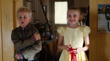 Movie still from “Charlotte's Web” (2006), directed by Gary Winick – A young girl in a yellow dress standing next to a young boy; Medium shot, Over the shoulder angle