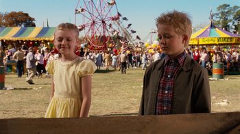Movie still from “Charlotte's Web” (2006), directed by Gary Winick – Two children standing in front of a ferris wheel in an amusement park; Medium shot, Over the shoulder angle