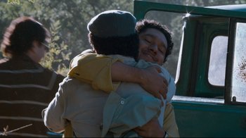 Movie still from “Che: Part Two” (2008), directed by Steven Soderbergh – Two people hugging each other in a forest; Medium shot, Low angle