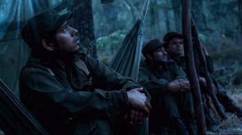Movie still from “Che: Part Two” (2008), directed by Steven Soderbergh – A group of men standing next to each other in the woods; Medium shot, Low angle