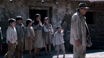 Movie still from “Che: Part Two” (2008), directed by Steven Soderbergh – A group of people standing next to each other on a street; Wide shot, Low angle