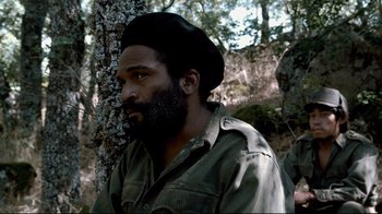 Movie still from “Che: Part Two” (2008), directed by Steven Soderbergh – A man with a beard wearing a hat and a jacket; Medium shot, Low angle