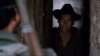 Movie still from “Che: Part Two” (2008), directed by Steven Soderbergh – A man wearing a black hat is looking at the camera; Close Up shot, Low angle