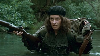 Movie still from “Che: Part Two” (2008), directed by Steven Soderbergh – A person in a boat in a body of water; Medium shot, High angle