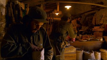 Movie still from “Che: Part Two” (2008), directed by Steven Soderbergh – A group of men standing next to each other in a room; Medium shot, Over the shoulder angle