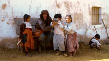 Movie still from “Che: Part Two” (2008), directed by Steven Soderbergh – A group of people standing next to each other on a dirt ground; Wide shot, Low angle