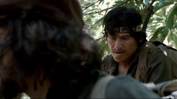 Movie still from “Che: Part Two” (2008), directed by Steven Soderbergh – A man with a bandana on his head looking at another man with long hair; Close Up shot, Over the shoulder angle