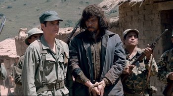 Movie still from “Che: Part Two” (2008), directed by Steven Soderbergh – A group of men standing next to each other; Medium shot, Over the shoulder angle