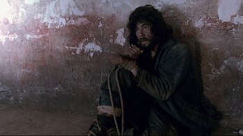 Movie still from “Che: Part Two” (2008), directed by Steven Soderbergh – A man holding a rope in his hands; Medium shot, High angle