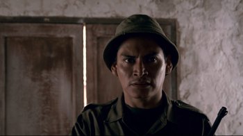 Movie still from “Che: Part Two” (2008), directed by Steven Soderbergh – A man wearing a green hat and a green shirt; Close Up shot, Low angle