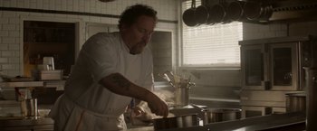 Movie still from “Chef” (2014), directed by Jon Favreau – A man in a kitchen preparing food in a pot; Medium shot, Low angle