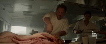 Movie still from “Chef” (2014), directed by Jon Favreau – A man in a kitchen cutting a piece of meat; Medium shot, Low angle