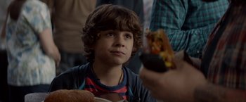 Movie still from “Chef” (2014), directed by Jon Favreau – A young boy is holding a hot dog in his hand; Close Up shot, Over the shoulder angle