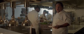 Movie still from “Chef” (2014), directed by Jon Favreau – A group of men in a kitchen preparing food; Medium shot, Over the shoulder angle