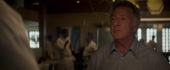 Movie still from “Chef” (2014), directed by Jon Favreau – An older man is looking at the camera while a group of people are in the background; Close Up shot, Over the shoulder angle