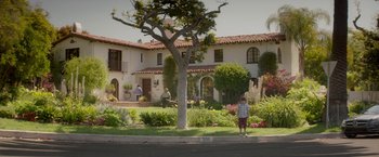 Movie still from “Chef” (2014), directed by Jon Favreau – A man standing in front of a tree in front of a house; Extreme Wide shot, High angle