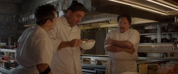 Movie still from “Chef” (2014), directed by Jon Favreau – A group of men in a kitchen preparing food; Medium shot, Over the shoulder angle