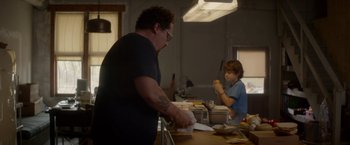 Movie still from “Chef” (2014), directed by Jon Favreau – A man and a boy in a kitchen preparing food; Medium shot, Over the shoulder angle