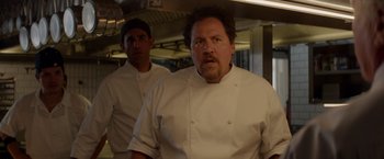Movie still from “Chef” (2014), directed by Jon Favreau – A man in a chef's outfit standing next to another man in a kitchen; Close Up shot, Over the shoulder angle