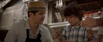 Movie still from “Chef” (2014), directed by Jon Favreau – A man and a boy in a kitchen talking to each other; Close Up shot, Over the shoulder angle