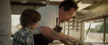Movie still from “Chef” (2014), directed by Jon Favreau – A man and a boy in a kitchen preparing food; Close Up shot, Over the shoulder angle