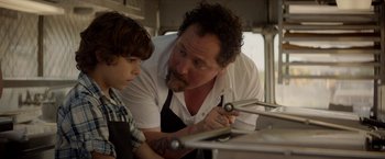 Movie still from “Chef” (2014), directed by Jon Favreau – A man and a boy working in a kitchen; Close Up shot, Over the shoulder angle