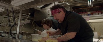Movie still from “Chef” (2014), directed by Jon Favreau – A man and a boy in a kitchen preparing food; Close Up shot, Low angle