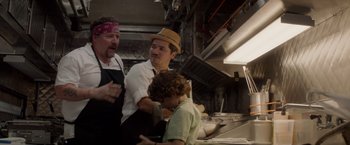 Movie still from “Chef” (2014), directed by Jon Favreau – A group of people in a kitchen preparing food; Medium shot, Over the shoulder angle