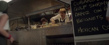 Movie still from “Chef” (2014), directed by Jon Favreau – A man wearing a hat is preparing food in a kitchen; Medium shot, Low angle