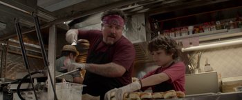 Movie still from “Chef” (2014), directed by Jon Favreau – A man and a boy preparing sandwiches in a kitchen; Medium shot, Over the shoulder angle