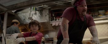 Movie still from “Chef” (2014), directed by Jon Favreau – A man and a child in a kitchen; Medium shot, Over the shoulder angle