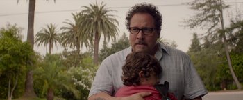 Movie still from “Chef” (2014), directed by Jon Favreau – A man holding a little girl in his arms; Close Up shot, Over the shoulder angle